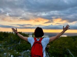 Woman with open arms facing horizon, symbolizing freedom and personal growth