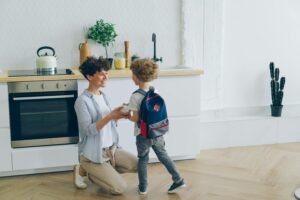 Smiling mother holding her child’s hand during a calm morning routine before school
