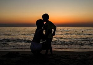 Mother and son looking at each other at sunset, symbolizing connection and presence